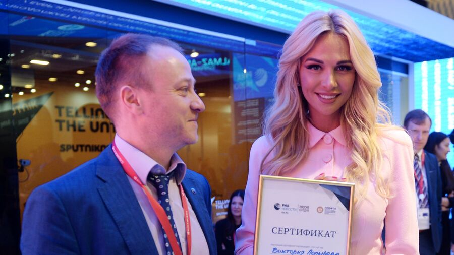 Заместитель главного редактора - директор главной дирекции информации МИА Россия сегодня Дмитрий Горностаев вручает сертификат выпускающего редактора фотомодели и телеведущей Виктории Лопыревой на стенде МИА Россия сегодня на ПМЭФ 2018 Заместитель главного редактора - директор главной дирекции информации МИА Россия сегодня Дмитрий Горностаев вручает сертификат выпускающего редактора фотомодели и телеведущей Виктории Лопыревой на стенде МИА Россия сегодня на ПМЭФ 2018