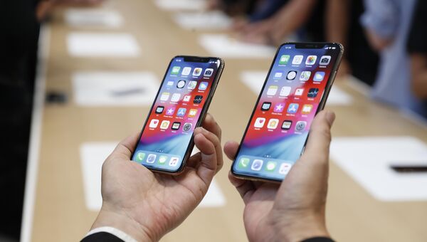 Человек держит новый Apple iPhone XS и XS Max. 12 сентября 2018 года Человек держит новый Apple iPhone XS и XS Max. 12 сентября 2018 года