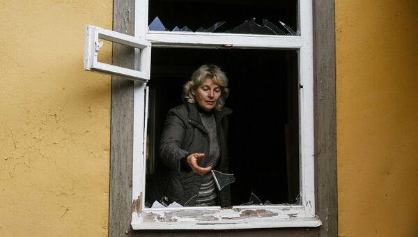 Местная жительница осматривает окно, выбитое в результате взрыва на военном складе в Черниговской области. 9 октября 2018 Местная жительница осматривает окно, выбитое в результате взрыва на военном складе в Черниговской области. 9 октября 2018
