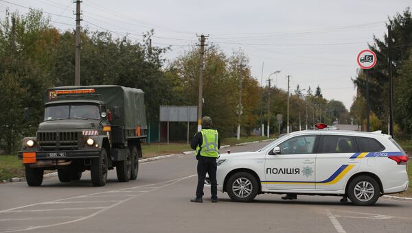 Сотрудники полиции Украины останавливают автомобили на дороге в Черниговской области после взрыва на военном складе. 9 октября 2018 Сотрудники полиции Украины останавливают автомобили на дороге в Черниговской области после взрыва на военном складе. 9 октября 2018