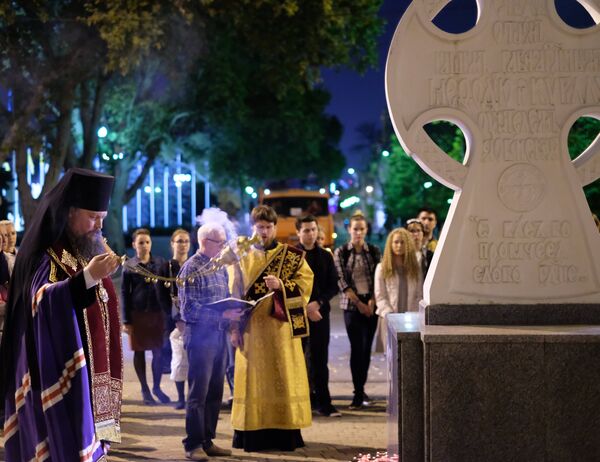Священнослужитель читает молебен у импровизированного мемориала в Краснодаре в память о погибших при нападении на керченский колледж Священнослужитель читает молебен у импровизированного мемориала в Краснодаре в память о погибших при нападении на керченский колледж