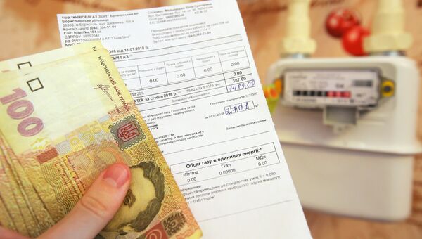 Денежные купюры Украины и квитанция за оплату коммунальных услуг. Архивное фото Денежные купюры Украины и квитанция за оплату коммунальных услуг. Архивное фото