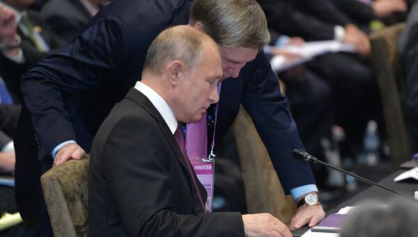 Президент России Владимир Путин и помощник президента Юрий Ушаков на пленарном заседании Восточноазиатского саммита в Сингапуре. 15 ноября 2018 Президент России Владимир Путин и помощник президента Юрий Ушаков на пленарном заседании Восточноазиатского саммита в Сингапуре. 15 ноября 2018