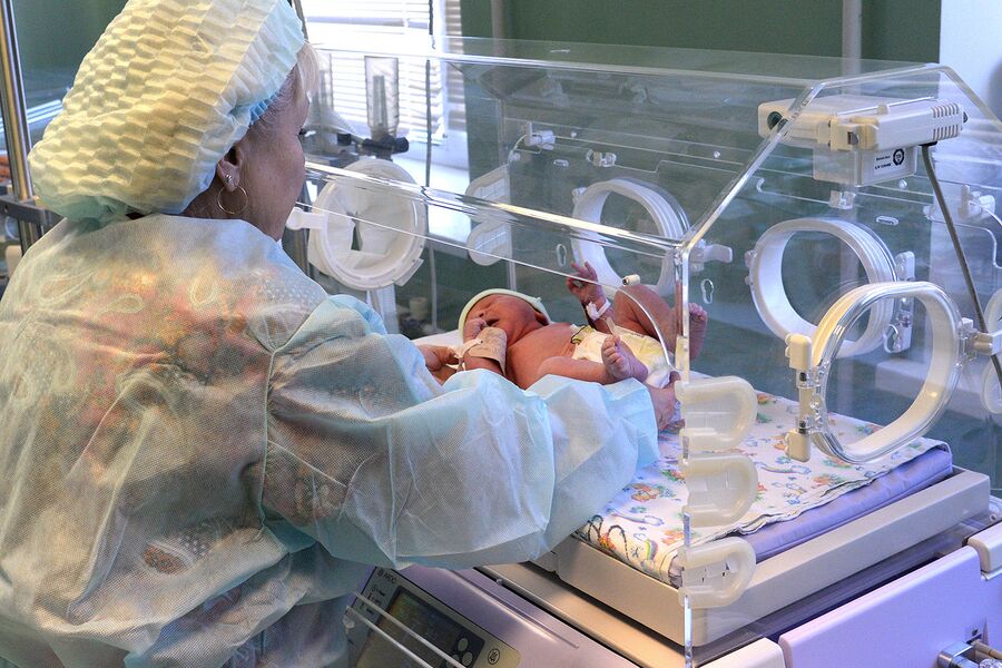 Медицинский работник и младенец в перинатальном центре Медицинский работник и младенец в перинатальном центре