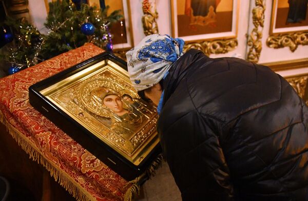 Женщина склоняется перед иконой Богоматери во время рождественского богослужения в храме святого апостола Андрея Первозванного во Владивостоке. 6 января 2019 Женщина склоняется перед иконой Богоматери во время рождественского богослужения в храме святого апостола Андрея Первозванного во Владивостоке. 6 января 2019