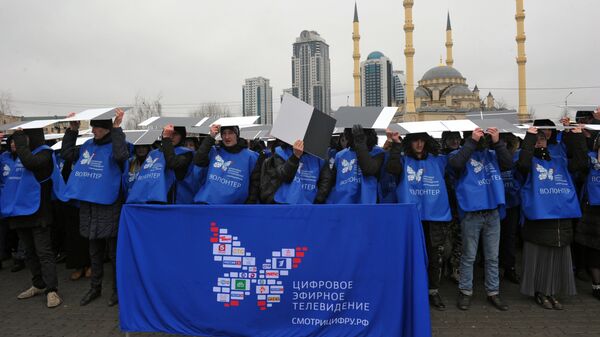 Волонтеры во время флешмоба в Грозном, посвященного отключению аналогового телевещания. 9 февраля 2019 Волонтеры во время флешмоба в Грозном, посвященного отключению аналогового телевещания. 9 февраля 2019
