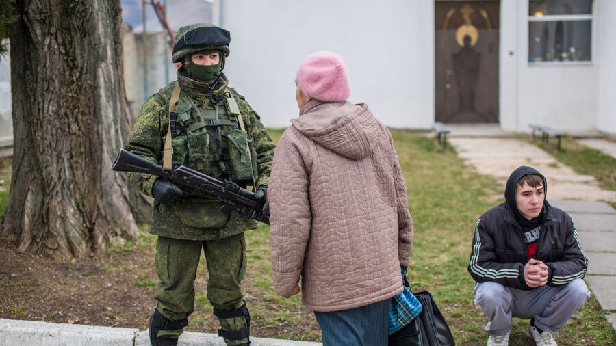 Местная жительница разговаривает с военнослужащим в селе Перевальное недалеко от Симферополя Местная жительница разговаривает с военнослужащим в селе Перевальное недалеко от Симферополя