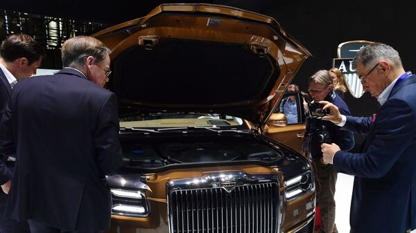 Посетители осматривают моторный отсек автомобиля Aurus Senat S600 на Международном Женевском автосалоне 2019 Посетители осматривают моторный отсек автомобиля Aurus Senat S600 на Международном Женевском автосалоне 2019