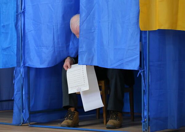Мужчина изучает бюллетень на президентских выборах на одном из избирательных участков Киева Мужчина изучает бюллетень на президентских выборах на одном из избирательных участков Киева