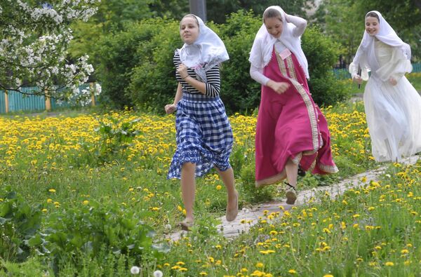 Девушки, бегущие в сарафанах и платках в день праздника Святых Жён-Мироносиц в духовном центре старообрядчества Рогожская слобода в Москве Девушки, бегущие в сарафанах и платках в день праздника Святых Жён-Мироносиц в духовном центре старообрядчества Рогожская слобода в Москве