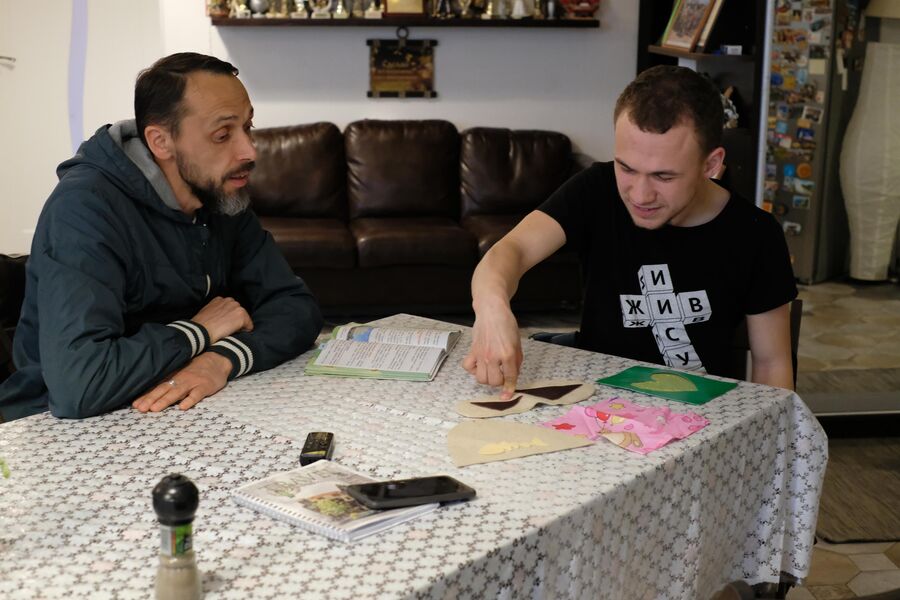 Витя показывает отцу Александру Горелову выкройки, которые он делал в колледже Витя показывает отцу Александру Горелову выкройки, которые он делал в колледже