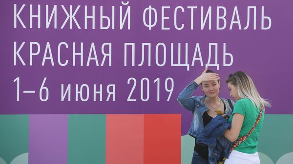 Посетительницы книжного фестиваля на Красной площади в Москве Посетительницы книжного фестиваля на Красной площади в Москве
