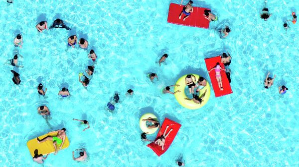 Люди отдыхают в бассейне в Ганновере, Германия