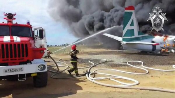 Сотрудники противопожарной службы тушат пожар на месте аварийной посадки самолёта Ан-24 в Нижнеангарске. Стоп-кадр с видео, предоставленного СК РФ
