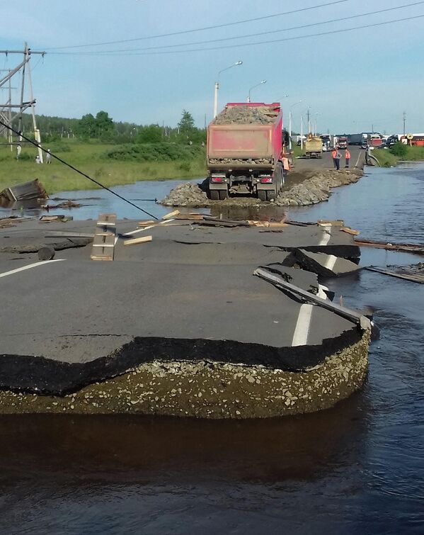 Самосвал насыпает щебень на разрушенном участке дороги в подтопленном городе Тулуне Иркутской области Самосвал насыпает щебень на разрушенном участке дороги в подтопленном городе Тулуне Иркутской области