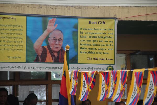 Плакат во дворе главного буддийского храма Дхарамсалы с изображением Далай-ламы и его словами о лучшем подарке