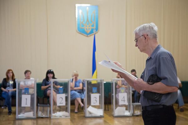 Избиратель изучает бюллетень на участке в Киеве, перед тем как проголосовать на досрочных выборах в Верховную раду Украины Избиратель изучает бюллетень на участке в Киеве, перед тем как проголосовать на досрочных выборах в Верховную раду Украины