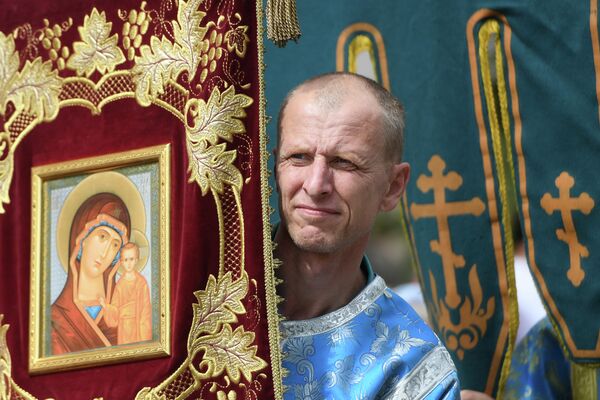 Священнослужитель во время крестного хода с иконой Казанской Божией Матери Священнослужитель во время крестного хода с иконой Казанской Божией Матери