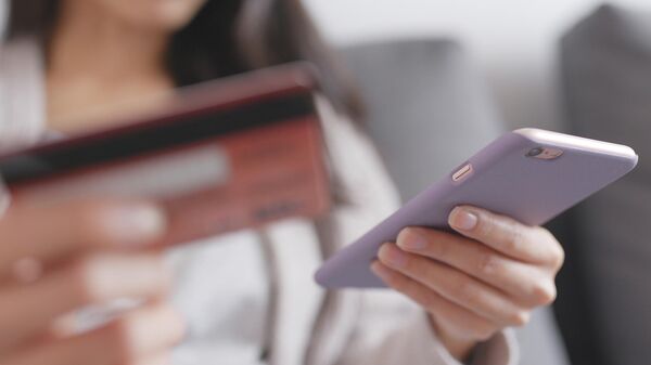 Девушка со смартфоном и банковской картой