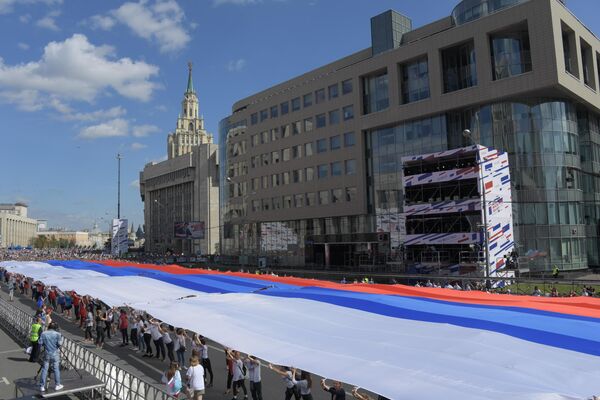 Участники флешмоба в честь Дня государственного флага России на проспекте Сахарова в Москве Участники флешмоба в честь Дня государственного флага России на проспекте Сахарова в Москве