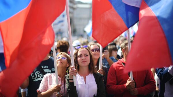 Участники флешмоба в честь Дня государственного флага России на проспекте Сахарова в Москве Участники флешмоба в честь Дня государственного флага России на проспекте Сахарова в Москве