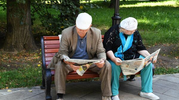 Пожилая пара на скамейке в парке