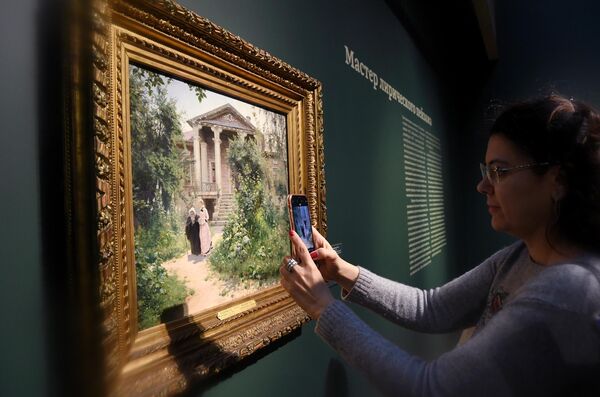 Посетительница фотографирует картину Василия Поленова Бабушкин сад в Третьяковской галерее на Крымском валу Посетительница фотографирует картину Василия Поленова Бабушкин сад в Третьяковской галерее на Крымском валу