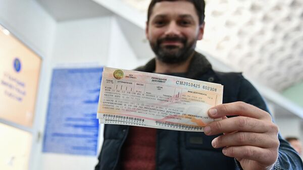 Мужчина демонстрирует купленный билет на железнодорожном вокзале в Симферополе Мужчина демонстрирует купленный билет на железнодорожном вокзале в Симферополе