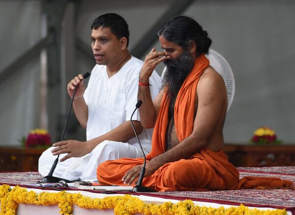 Индийский гуру йоги Свами Рамдев и управляющий директор компании Patanjali Ayurved на семинаре по йоге в Ахмадабаде. 20 июня 2017 года Индийский гуру йоги Свами Рамдев и управляющий директор компании Patanjali Ayurved на семинаре по йоге в Ахмадабаде. 20 июня 2017 года