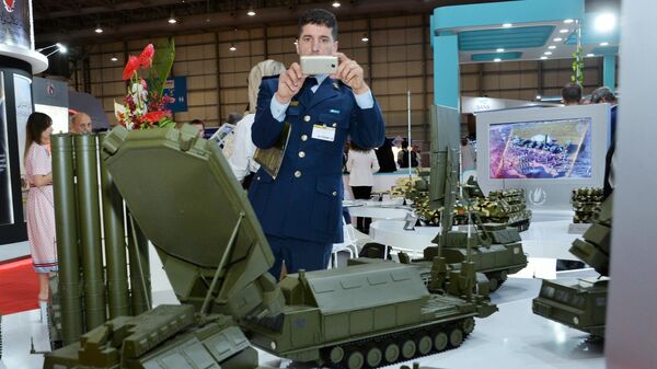 Посетитель выставки осматривает макеты военной техники, представленные на стенде АО Рособоронэкспорт на международном авиасалоне Dubai Airshow 2019 в Дубае Посетитель выставки осматривает макеты военной техники, представленные на стенде АО Рособоронэкспорт на международном авиасалоне Dubai Airshow 2019 в Дубае