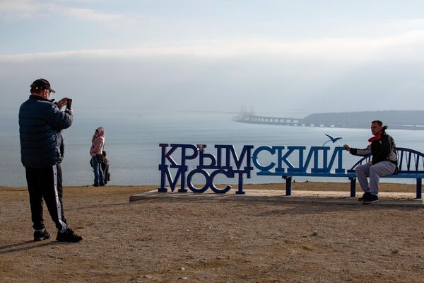 Люди фотографируются напротив Крымского моста Люди фотографируются напротив Крымского моста