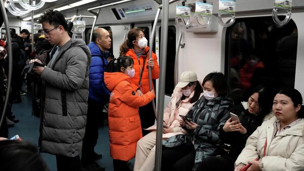 Люди носят маски во время поездки в метро в Пекине, Китай. 21 января 2020 Люди носят маски во время поездки в метро в Пекине, Китай. 21 января 2020