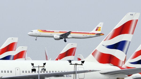 Взлетевший лайнер Iberia на фоне ждущих своей очереди самолетов British Airways Взлетевший лайнер Iberia на фоне ждущих своей очереди самолетов British Airways