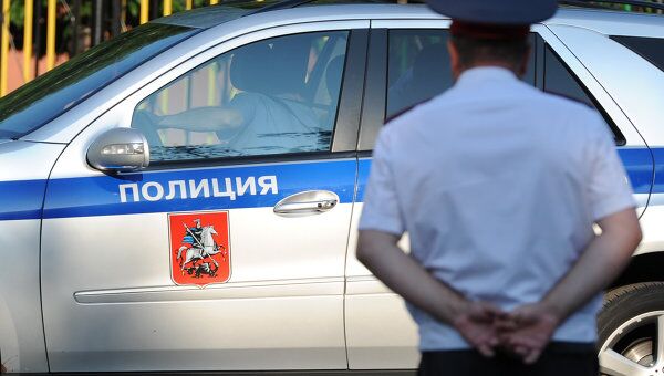 Полицейский автомобиль и сотрудник полиции. Архивное фото Полицейский автомобиль и сотрудник полиции. Архивное фото