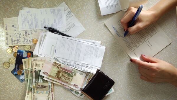 Женщина заполняет квитанцию на оплату коммунальных платежей. Архивное фото Женщина заполняет квитанцию на оплату коммунальных платежей. Архивное фото