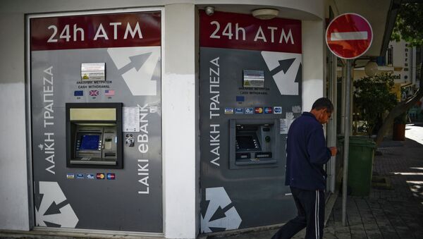 Мужчина проходит мимо банкоматов Cyprus Popular Bank (CPB). Архив Мужчина проходит мимо банкоматов Cyprus Popular Bank (CPB). Архив