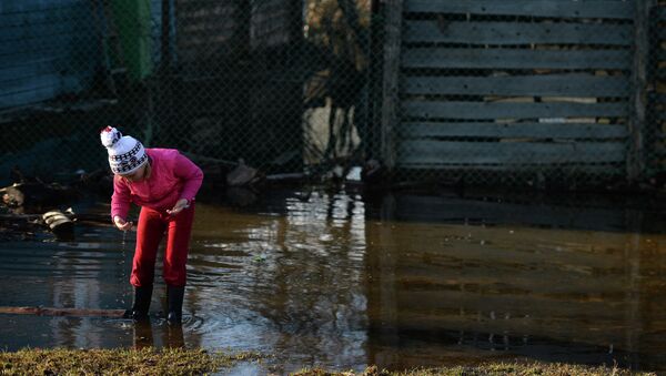 Девочка играет во дворе подтопленного дома Девочка играет во дворе подтопленного дома