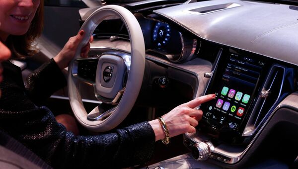 Женщина демонстрирует дисплей с функцией CarPlay на автосалоне в Женеве. Фото с места события Женщина демонстрирует дисплей с функцией CarPlay на автосалоне в Женеве. Фото с места события