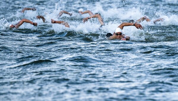 Спортсмены во время соревнований по плаванию на открытой воде на 5 км Спортсмены во время соревнований по плаванию на открытой воде на 5 км