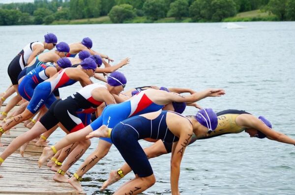 Спортсменки во время соревнований по триатлону в эстафете Спортсменки во время соревнований по триатлону в эстафете